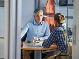 Twee Mannen In Gesprek aan een bureau