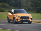 Ford Mustang Mach E GT geel aan het rijden op een racebaan voorkant