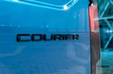 Ford E-Transit Courier courier embleem op de achterkant van een blauwe bus