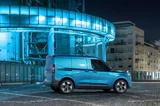 Ford E-Transit Courier blauw zijkant geparkeerd bij een blauw gebouw