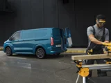 Ford E-Transit Custom met een man die aan het klussen is